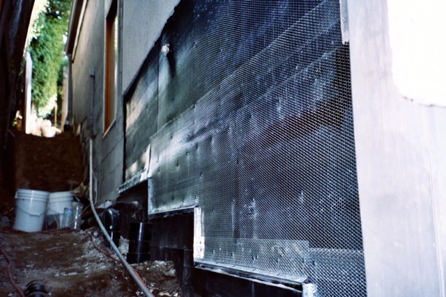 Waterproofing membrane applied over foundation and stucco