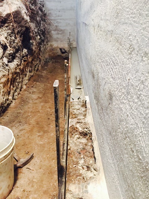 Applying rapid set cement to foundation footing voids