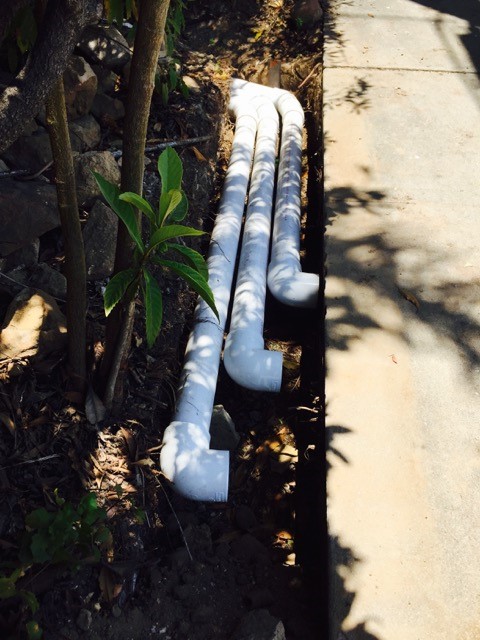 Drainage pipes extending to sidewalk