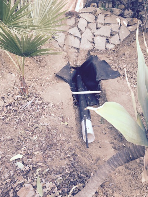 French drain sloped to hillside discharge area