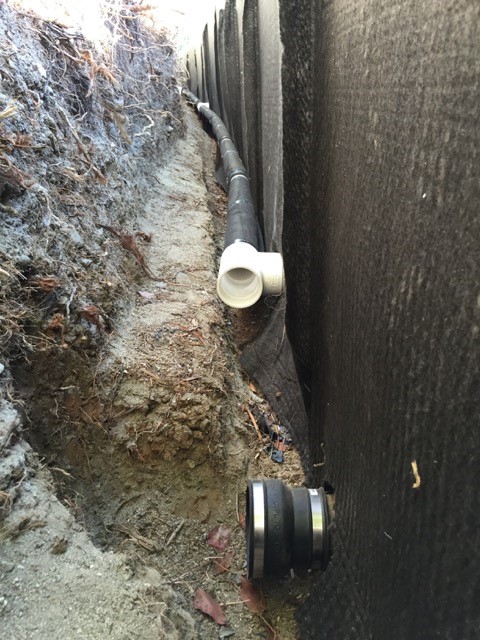 French drain connected to core through planter wall