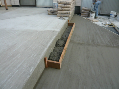 Elevated deck transition expansion joints extend through sloping mortar bed